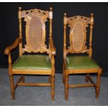 A set of six early 20th century oak dining chairs, each having scroll carved rail, cane