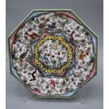 A reproduction French faience octagonal charger, decorated with panels of animals and flowers,