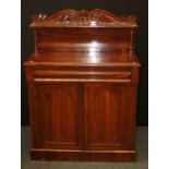 A Victorian rosewood chiffonier, the scroll carved panelled upstand over ogee frieze drawer and a