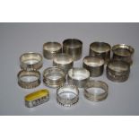 A collection of fourteen hallmarked silver and other white metal serviette rings, various dates