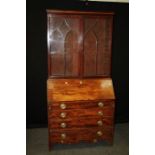 A George III bureau and associated bookcase, the bookcase enclosed by a pair of glazed panel door,
