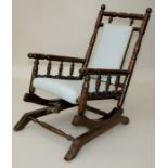 An Edwardian beech bobbin turned childs rocking chair armchair with sky blue upholstered back and