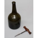 An 18th/19th century green glass wine/spirit bottle and wooden handled corkscrew, brush missing