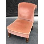 A Victorian walnut framed, salmon pink upholstered nursing chair, with rolled back, overstuffed