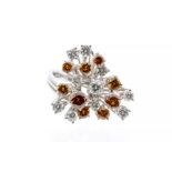 A diamond and 18ct white gold cluster, comprising a twisted claw setting of round cut cinnamon and