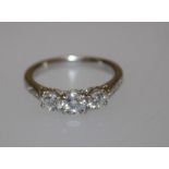 A platinum diamond ring, claw set three round brilliant cut diamonds with five small graduated