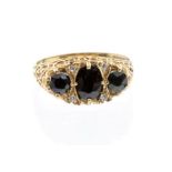 A sapphire and diamond 9ct gold three stone ring, comprising an oval sapphire set to the centre with