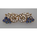 An Indian yellow gold white and blue sapphire brooch styled as a mask, with central hoops set