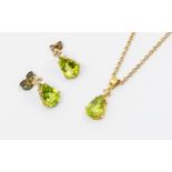 A peridot and diamond 9ct gold pendant and earring set, comprising a pendant with a claw set pear
