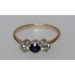 A three stone sapphire and diamond ring, round cut sapphire, flanked by two old cut diamonds,