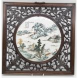 Early 20th Century round Chinese porcelain plaque in carved hard wood frame with flower detail
