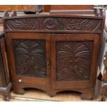 A small carved Victorian cupboard in oak, carved front panel with top gallery and internal shelves