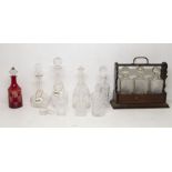 A Victorian stained wood tantalus with key and three moulded glass spirit decanter, together with