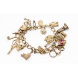 A silver charm bracelet complete with various silver and white metal charms including well, stork,