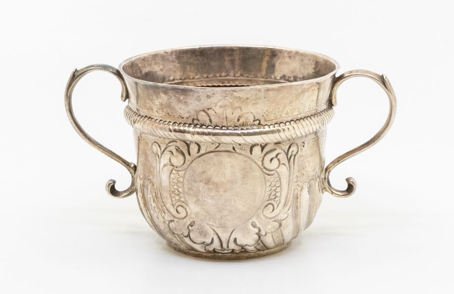 A Queen Anne Britannia standard silver two handled porringer, rope twist band above wyvern fluted