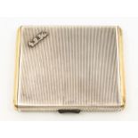An Art Deco Continental white metal cigarette case, striated cover and back with gilt sides, the