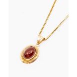 A carnelian and 9ct gold pendant, comprising a central oval cabochon citrine within a border of rope