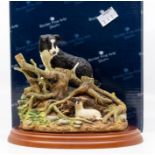 A boxed Border Fine Arts dog and sheep figure from the James Herriot series