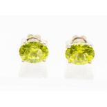A pair of silver and peridot stud earrings, claw set with oval peridots, approx. 8 x 5mm, post and