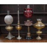 Four 19th century brass oil lamps including different coloured shades - all in good condition.