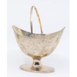 A George III silver boat shaped sugar basket, swing handle, engraved decoration, on oval foot,