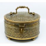 An Asian brass large cricket box, circular with engraved floral openwork decoration, ornate carrying