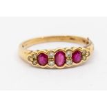 A ruby and diamond 9ct gold ring, comprising three oval cut rubies with double set diamond