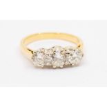 A three stone diamond and 18ct gold ring, comprising three round brilliant cut diamonds with a total