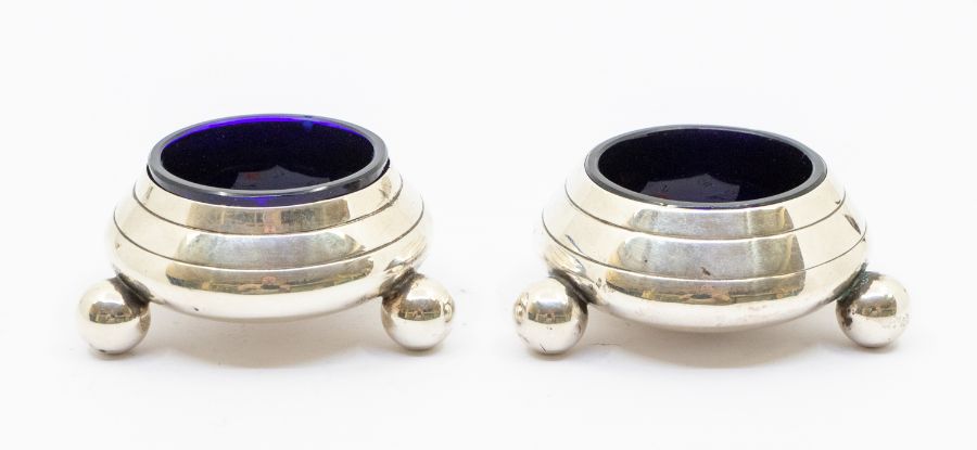 A pair of Victorian silver circular salts on three ball feet, hallmarked by Hancocks, London,