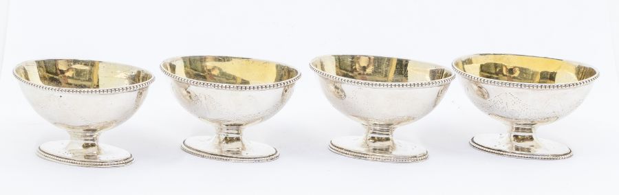 A matched set of four George III silver salts, boat shaped with beaded rims, engraved festoon