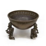 A large Indian bronze bowl with three angel figures as legs, with pierced detail to rim