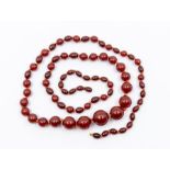 A cherry amber type necklace, comprising round and oval graduated beads, length approx. 30'', the