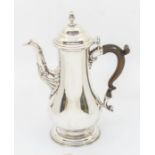 A George II silver pear shaped coffee pot, domed cover with acorn finial, acanthus decoration to