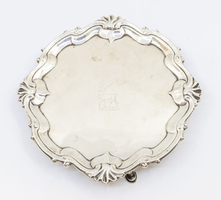 A George II cartouche shaped card tray / small salver, with raised stylised rocaille border, the