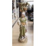 A Royal Dux figural vase, in the form of a lady carrying a vessel, standing next to a palm tree,