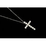 A diamond and 18ct white gold cross, claw set with round brilliant cut diamonds, total diamond