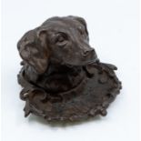 A late 19th Century Russian inkwell cast in the form of a Dog's head on scrolling base, stamped to