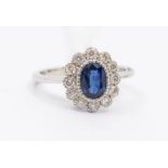 A sapphire and diamond 18ct white gold cluster ring, comprising an oval sapphire set to the