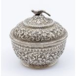 An Asian silver circular bowl and cover, profusely chased and engraved decoration, the cover with