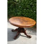 A Victorian walnut centre table, the circular top raised on a pedestal base, standing on four