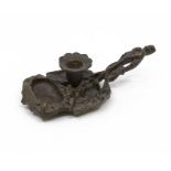 A bronze candle holder, early 20th Century in the style of leaves and flowers