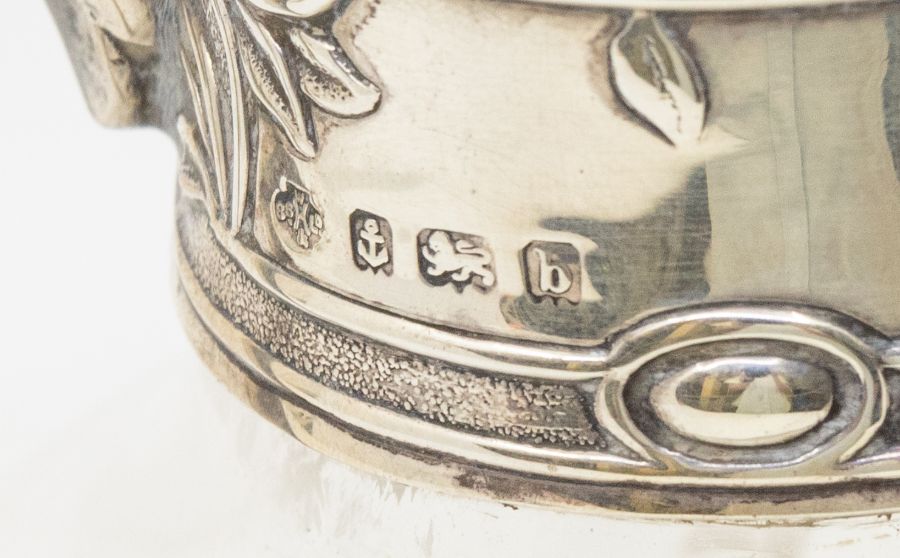 An Edwardian silver mounted claret jug, the mount chased with stylised flowers, with domed cover and - Image 2 of 2