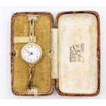 An early 20th Century ladies 9ct gold watch, round white enamel dial with pained numerals, gold tone