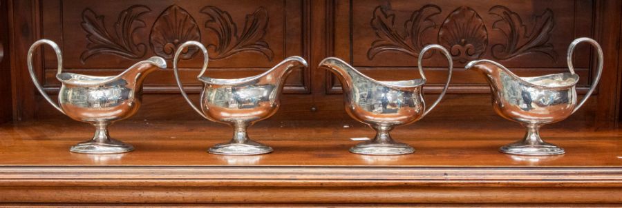 A set of four George III ogee shaped sauce boats, beaded border and foot rims, reeded loop handles