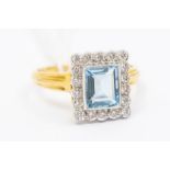 An aquamarine and diamond 18ct gold cluster ring, comprising a rub- over set central rectangular cut