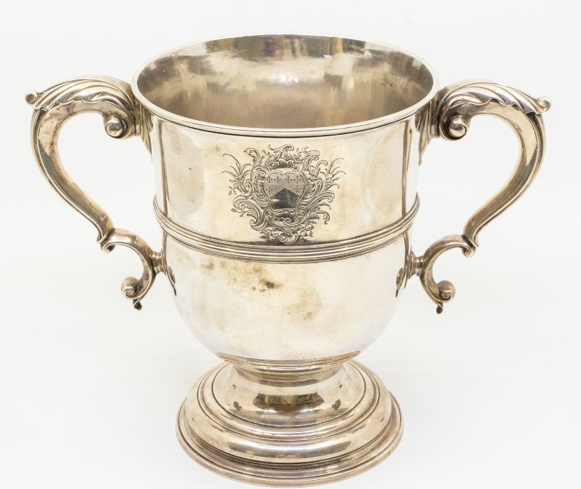 A George II large plain silver two handled loving cup / trophy, central mid rib, scroll handles with