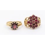 Two garnet and 9ct gold dress rings to include a cluster with fancy wire work scrolled shoulders,