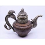 A Tibetan  silver teapot 18th century, the teapot is chased and engraved all over with scrolling