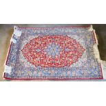 A fine quality part silk Qum rug.107cm by 157cm red ground