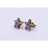 A pair of star shape diamond earrings (butterfly stamped '750')each set five and brilliant cut